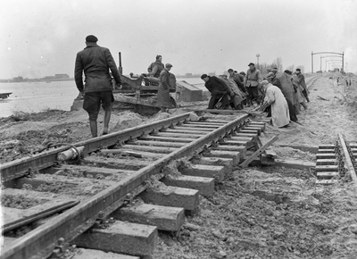 152850 Afbeelding van de herstelwerkzaamheden aan de verzakte spoorlijn bij Moerdijk kort na de watersnoodramp.